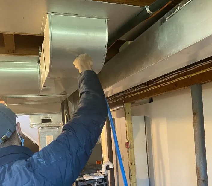 Residential HVAC duct coating service in New Jersey performed by a technician for improved air quality and energy efficiency